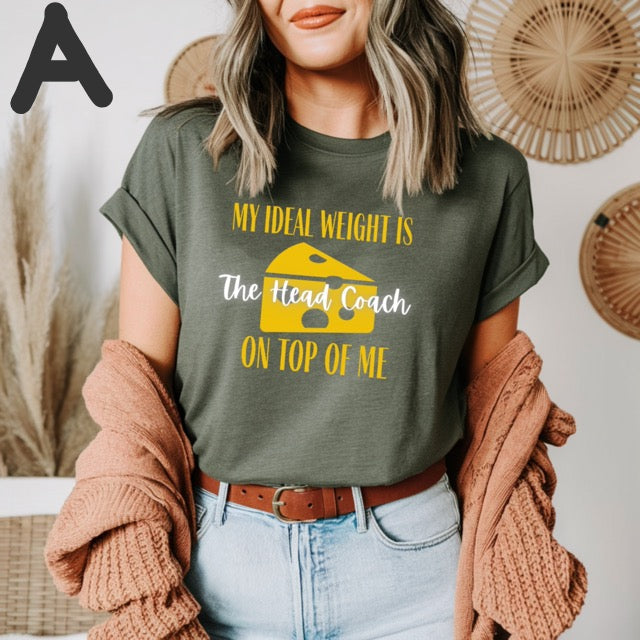 Person wearing a green t-shirt with humorous text and graphic, standing against a neutral background.