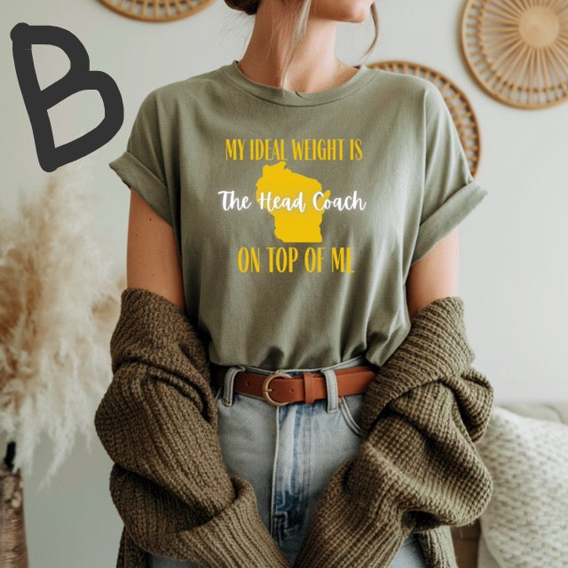 Person wearing a green t-shirt with a humorous graphic and text, standing in a cozy room.